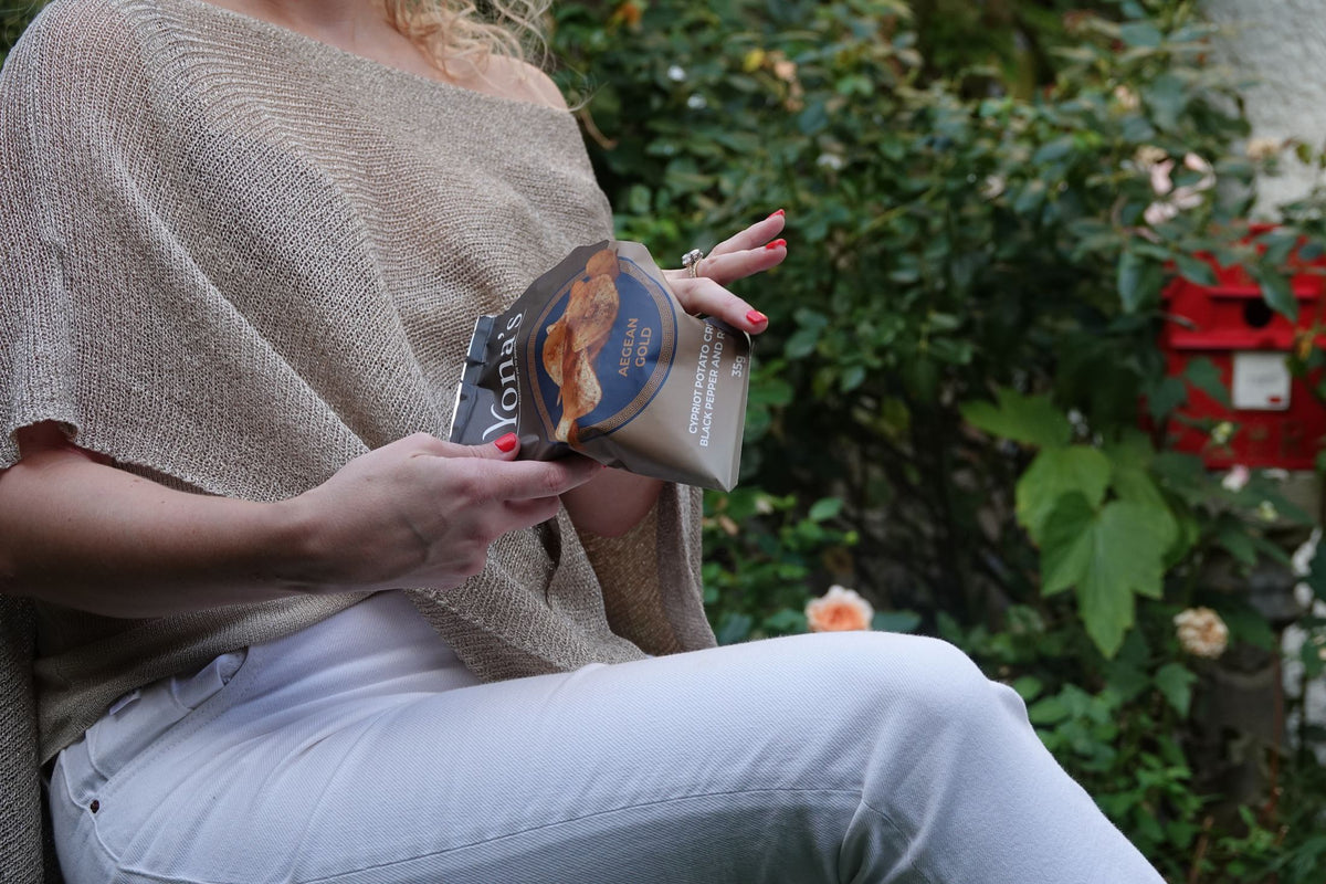 Hands opening a bag of Aegean Gold in the garden
